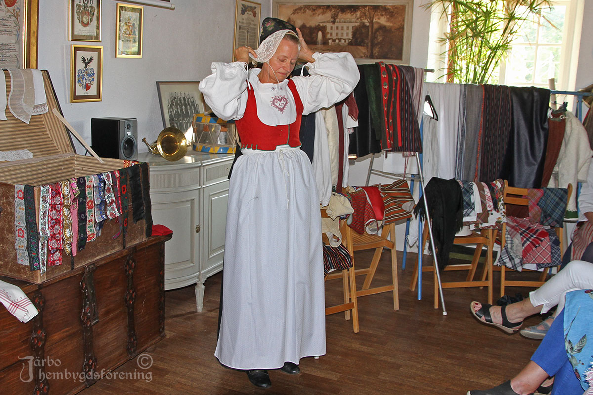 Efter att det vita stycket lagts på plats ska bindmössa på. Till högsta helg i kyrkan skulle mössan alltid vara svart, men mössbandet kunde varieras efter tycke och smak.