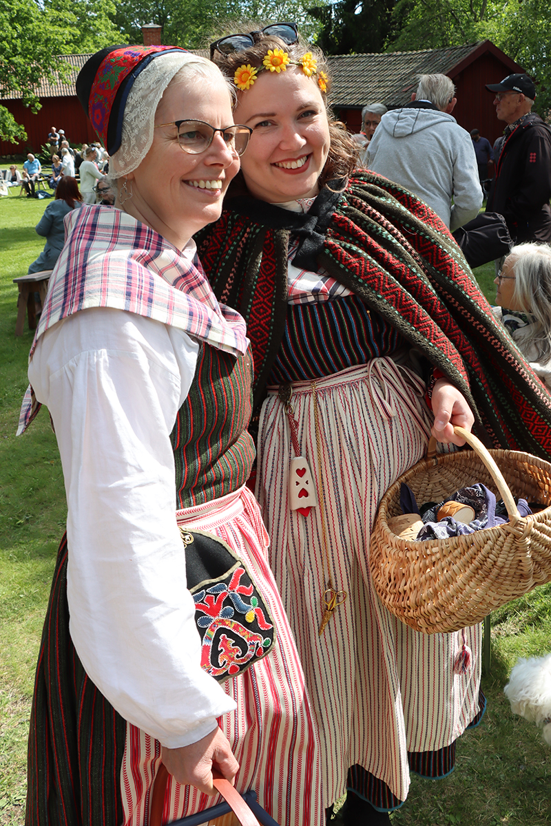 ovansjo-l_4126 Susanne från Ovansjö folkdanslag klädd i vardagsdräkt från ovansjö med slöjdlärare Hanna från Västerbergs folkhögskola som visar upp sitt nyvävda yvtäcke från Ovansjö över en dräkt från Torsåker.