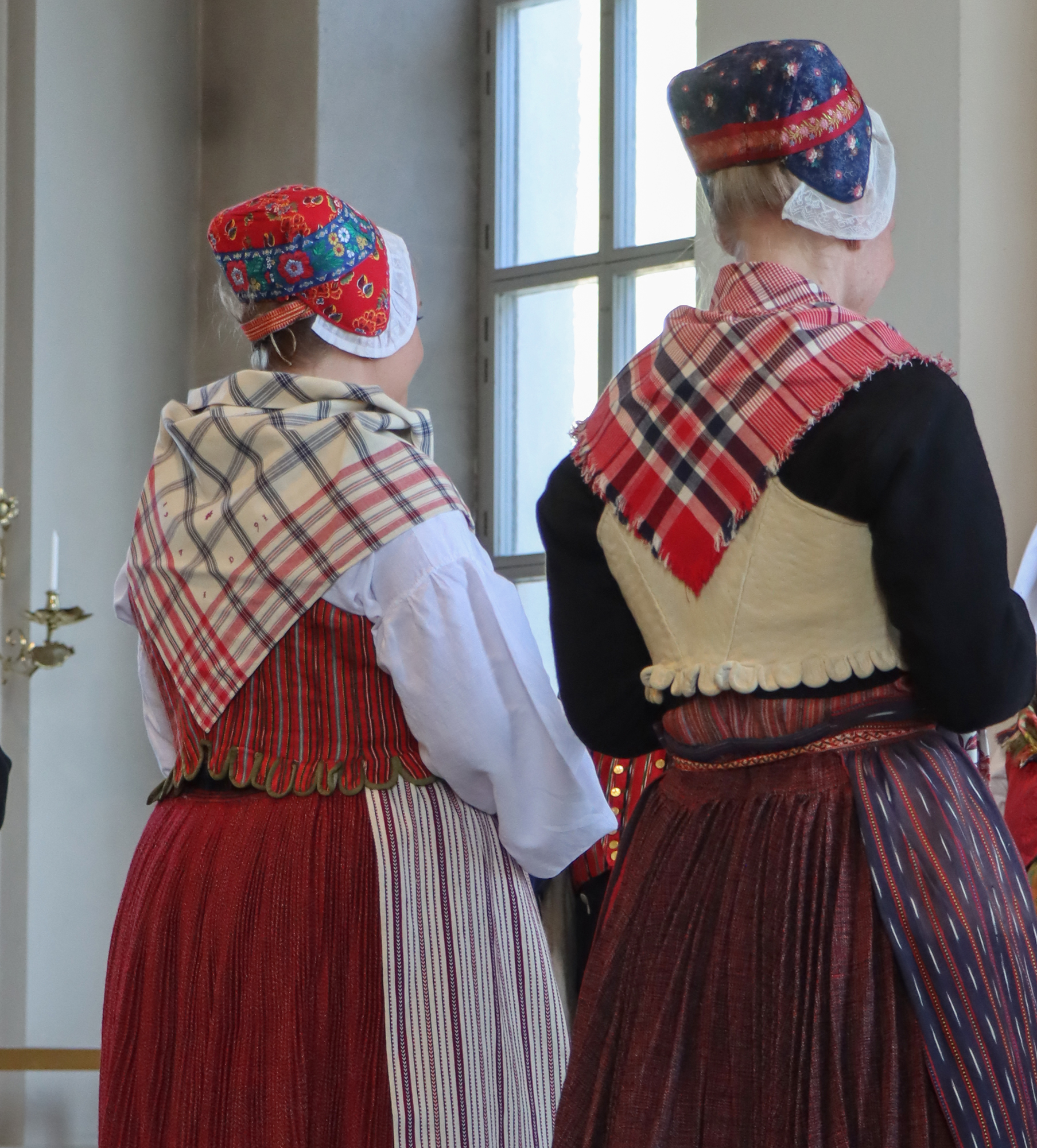 Dräkterna är minst lika vackra sedda från baksidan. Ogifta kvinnor bar halskläden och förkläden med mera rött, gifta kvinnor klädde sig i mörkare färger.